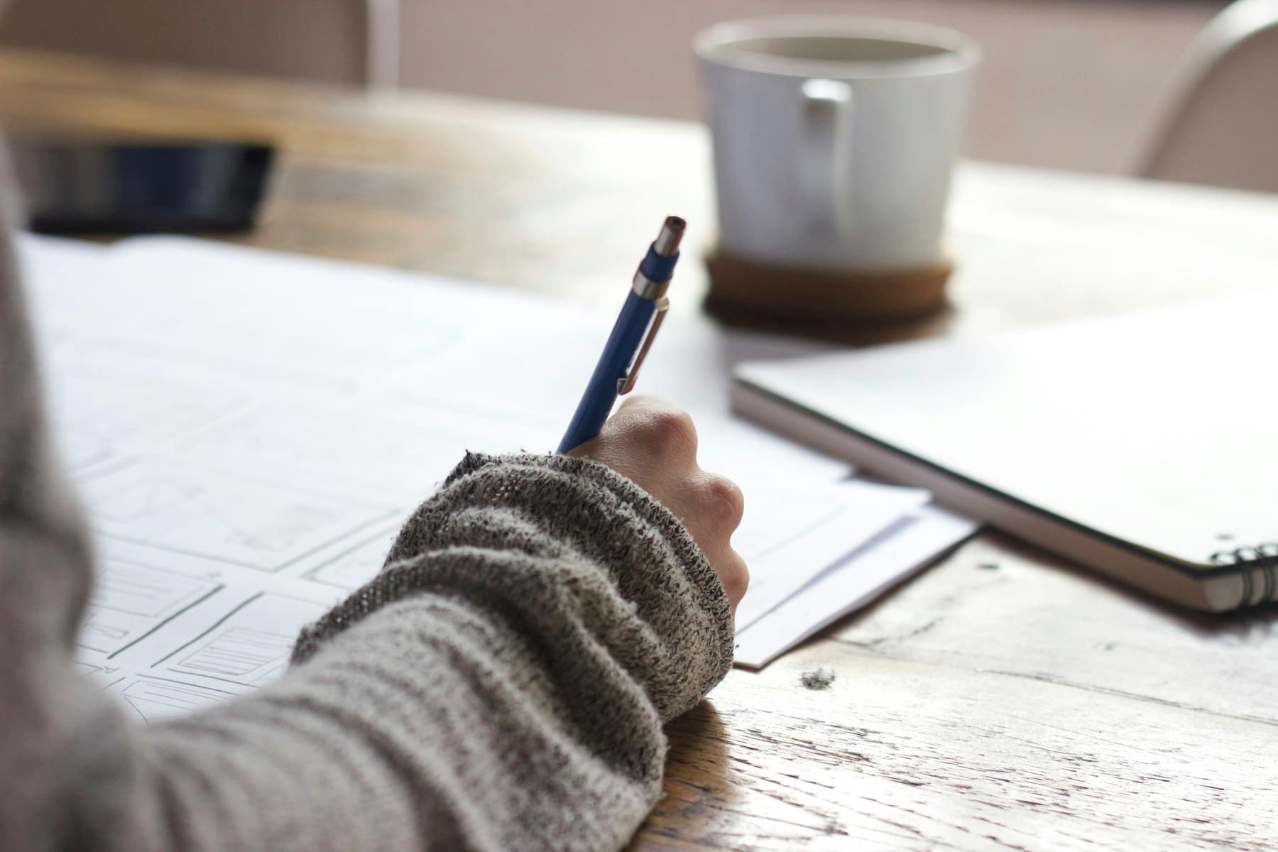 A student working through written material at a desk
